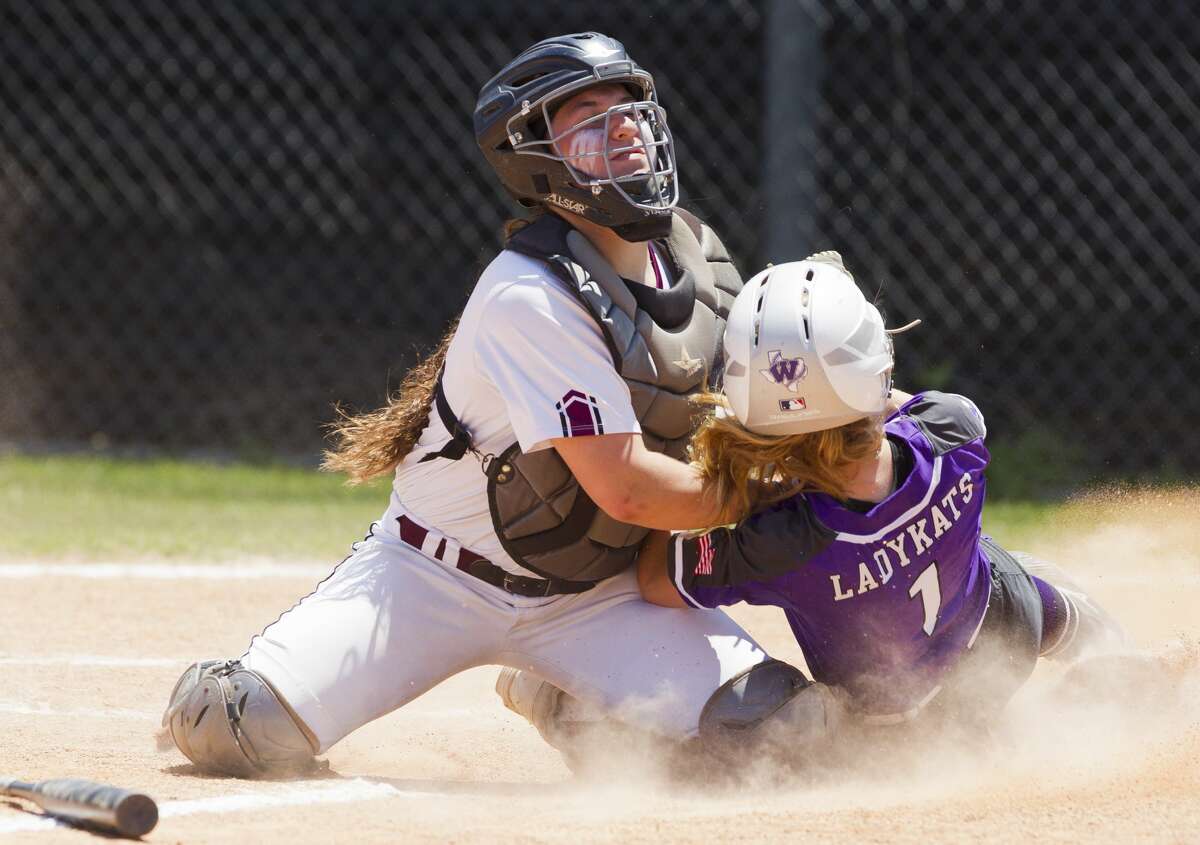 Magnolia catcher Alex DuBose (12) tags out Tyler Heffernan #1 of Willis at home plate during the fourth inning in Game 3 of a Region III-5A bi-district softball playoff match, Saturday, April 27, 2019, in Conroe.
