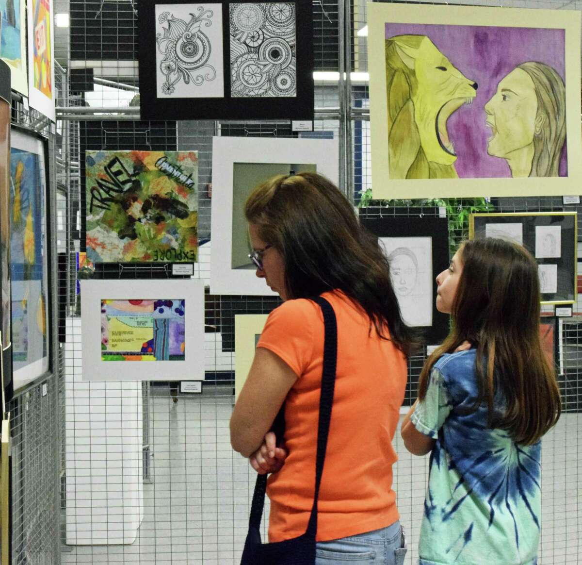 Julia Squeglia and her daughter, Ava, peruse the variety of art mediums at the art show.