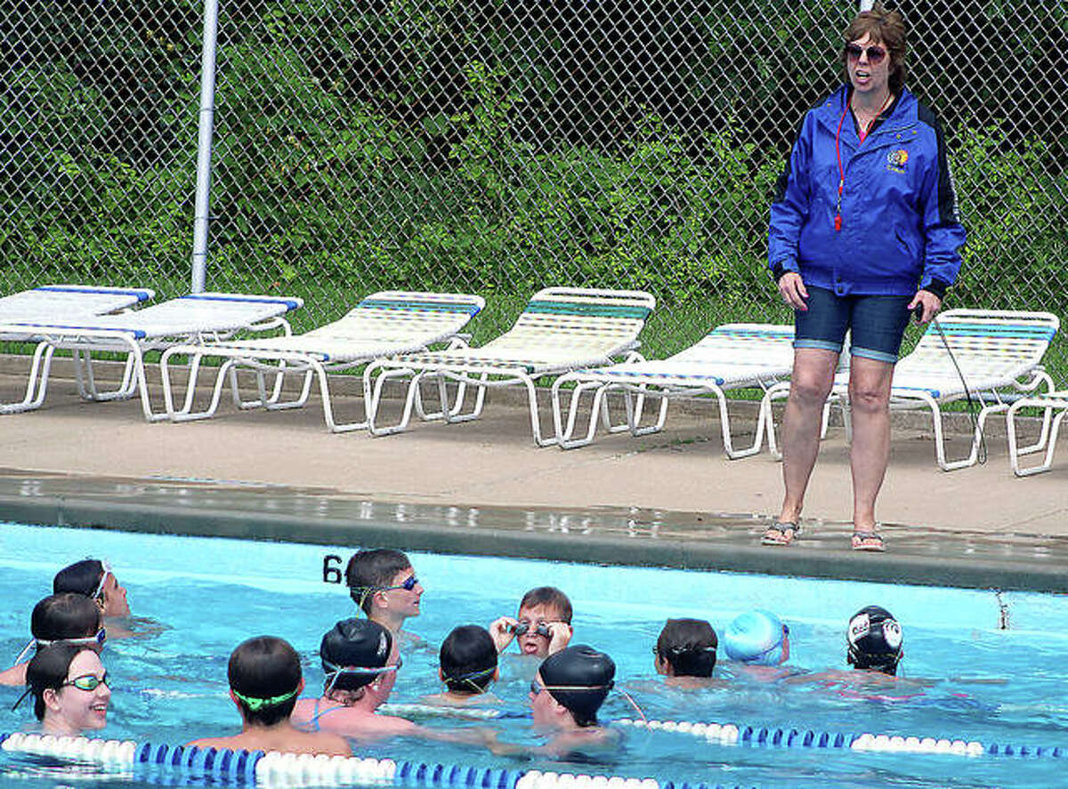 Summers Port swim coach Nancy Miller talks to a group of swimmers during practice Tuesday at the pool in Godfrey. The Sharks, who saw their 24-year reign as Southwestern Illinois Swim Association swim champs ended last season, are prepping for their season opener June 13 against Montclaire in Edwardsville.