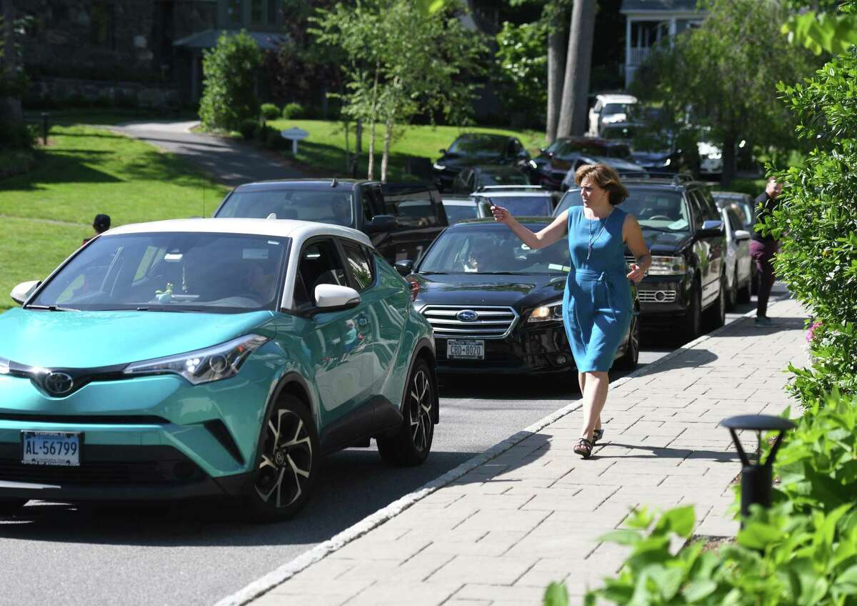 Director of Development Lisa Ferraro escorts cars out of the pick up loop during dismissal at Eagle Hill School in Greenwich, Conn. Tuesday, June 4, 2019.