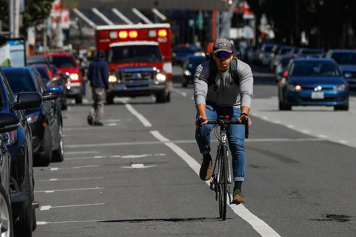 A biker rides on Howard Street where a cyclist was killed last Friday after being struck by a vehicle in San Francisco, California, on Monday, March 11, 2019
