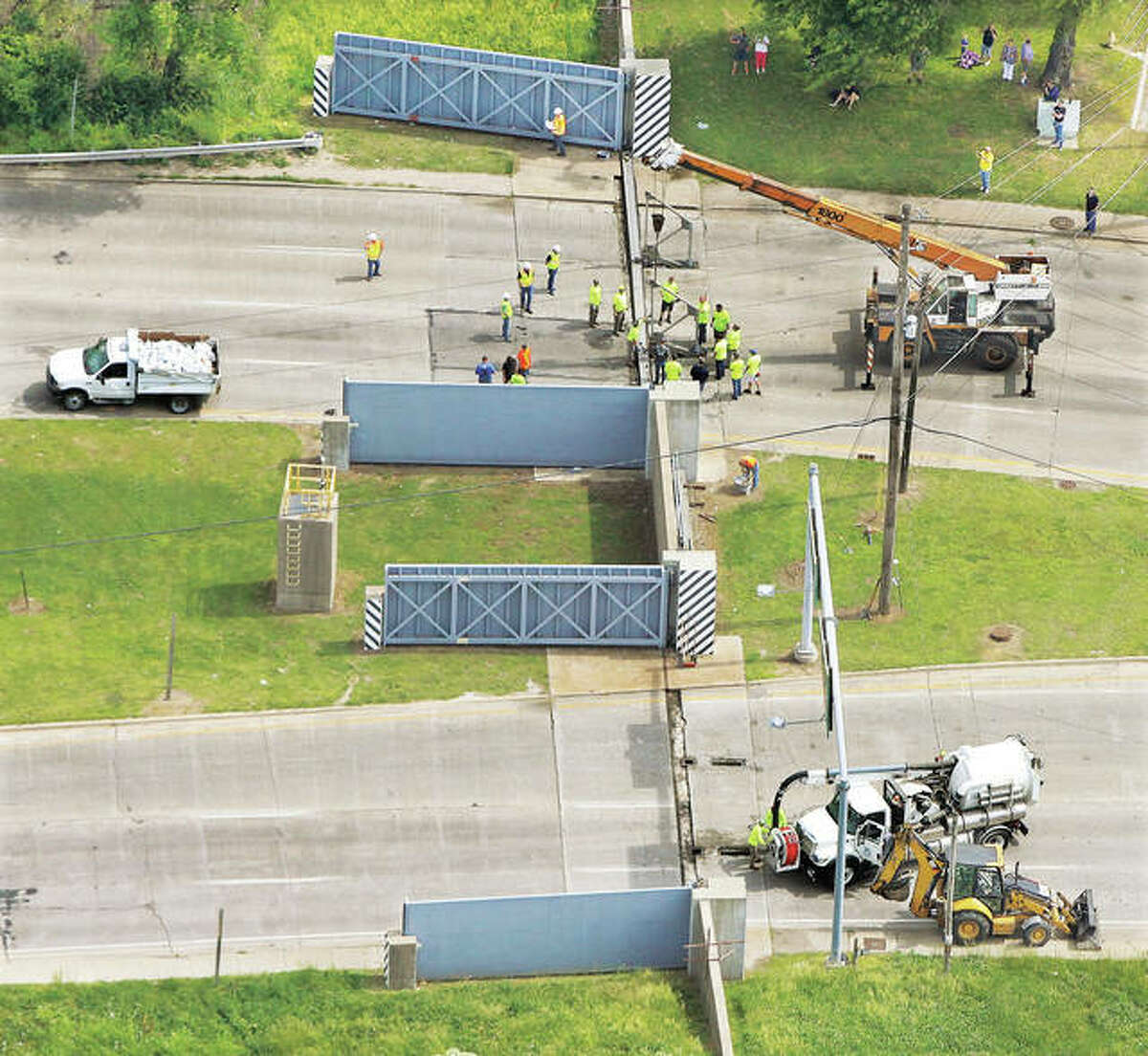 As seen from the air, a small army of workers took to the task Tuesday morning working to close the flood gates on Illinois 3 at the Alton/East Alton line for only the second time in history. Additional photos are on page C-1.