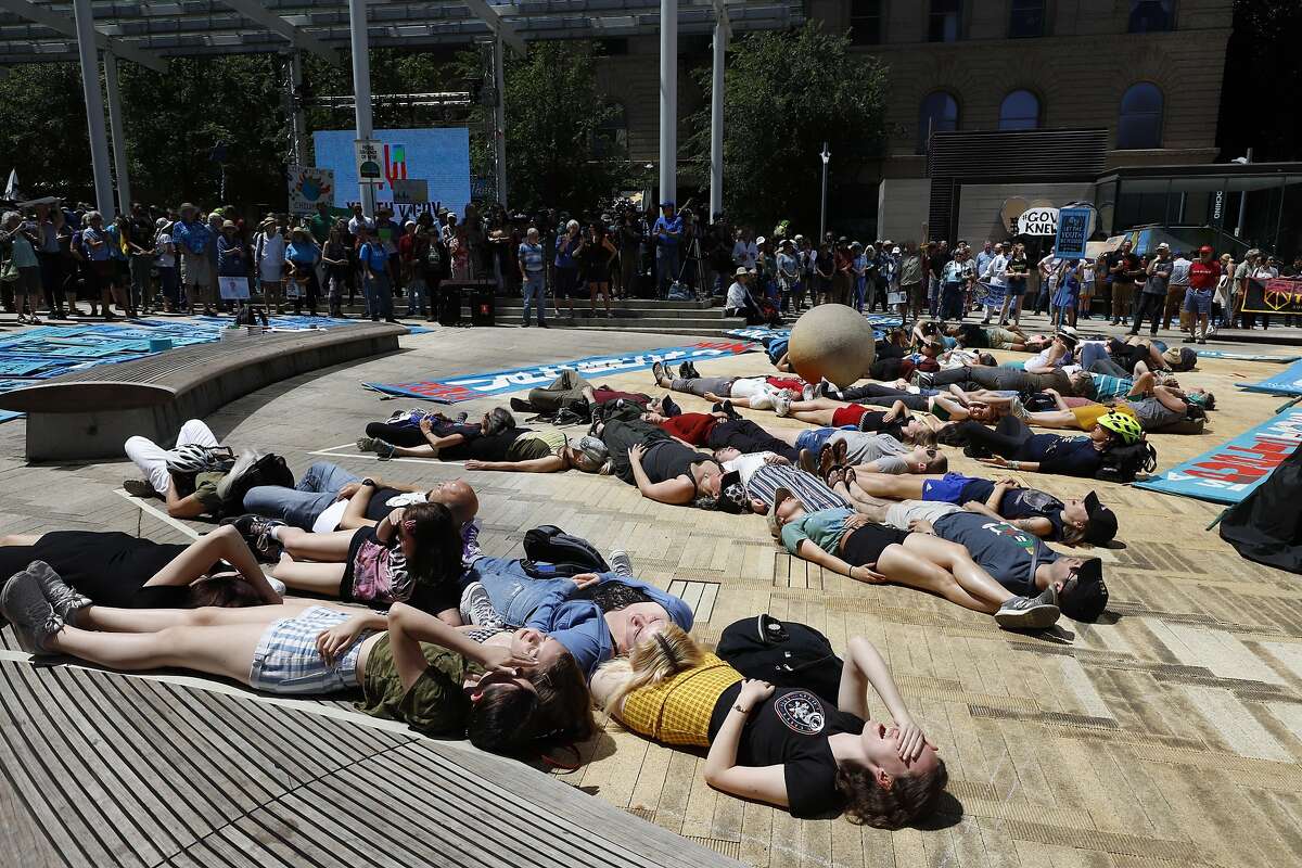 Supporters spell out a message with their bodies at a rally Tuesday, June 4, 2019 for a group of young people who filed a lawsuit saying U.S. energy policies are causing climate change and hurting their future. The group faces a major hurdle Tuesday as lawyers for the Trump administration argue to stop the case from moving forward. in Portland, Ore. (AP Photo/Steve Dipaola)