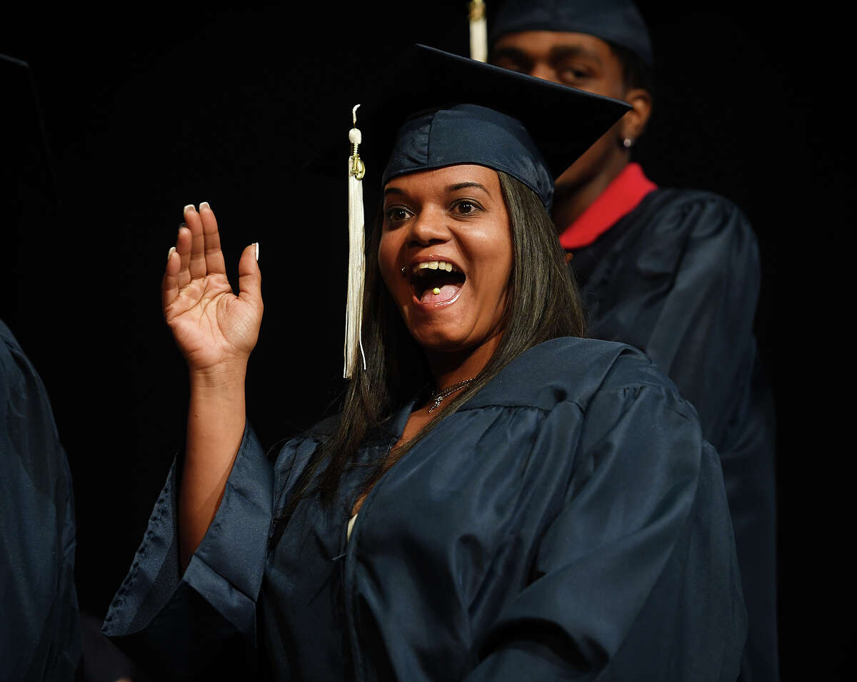 Graduate Sandra Lopez waves to family as she crosses the stage during the Bridgeport Adult Education Graduation at the Klein Memorial Auditorium in Bridgeport, Conn. on Tuesday, June 3, 2019.