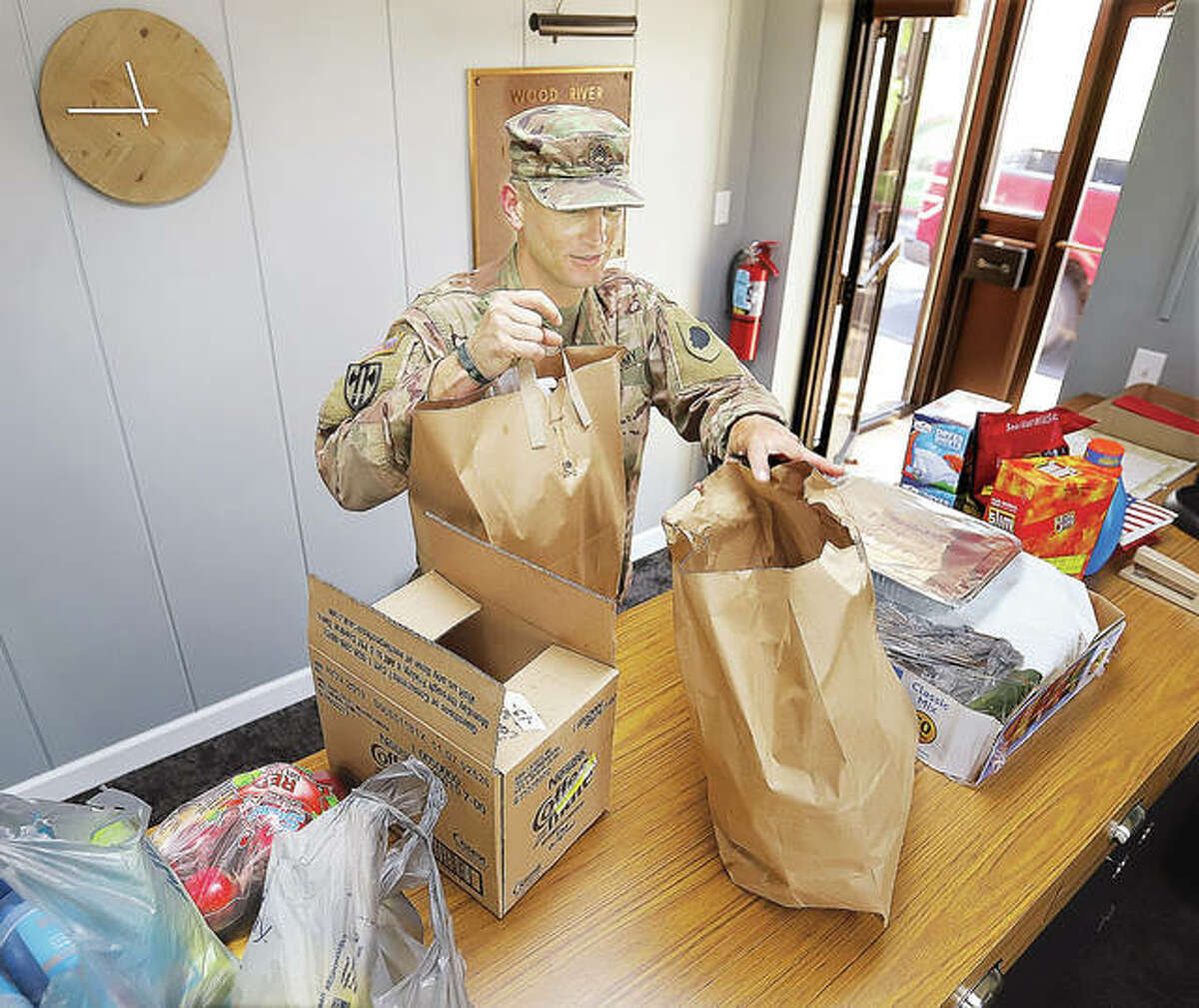 Illinois National Guard Staff Sgt. Josh Griffen picks up lunch for himself and his men Wednesday at the offices of the Wood River Levee District. Riverbend Family Ministries in Wood River has been coordinating to collect food for the guard troops who are patroling the length of the levee to protect it from damage and sightseers.