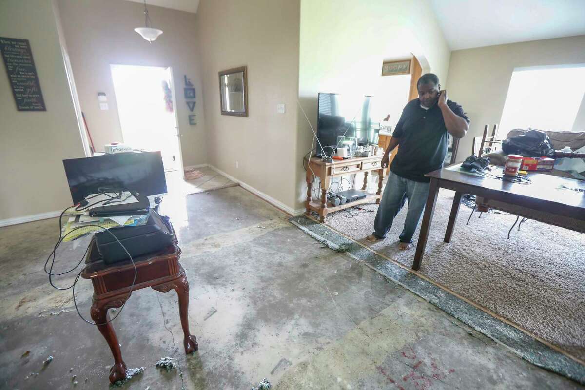 Adrian Moore, takes a break from ripping up his flood damaged carpet, said he has lived in his home for 6 1/2 years and it has never flooded until today Wednesday, June 5, 2019, in Kendleton.