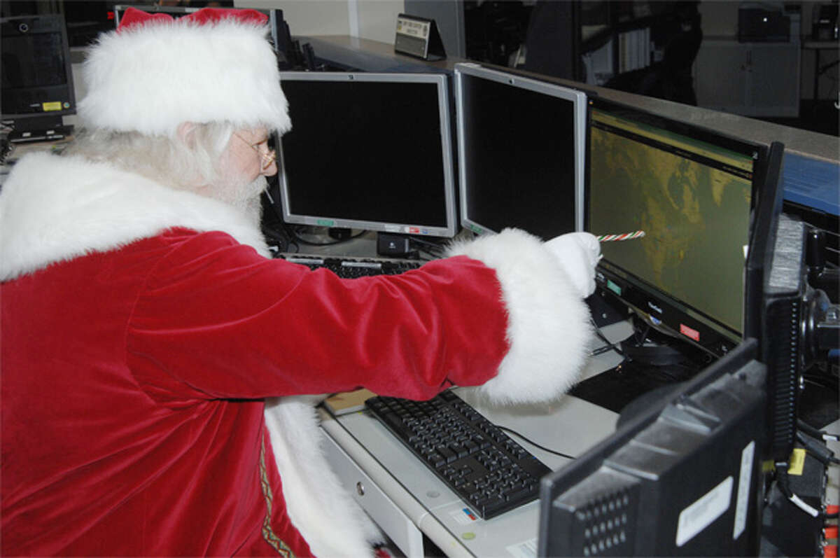 In Septmber, Santa Claus reviews his flight plan for his Dec. 25 trek across the globe in the North American Aerospace Defense Command and U.S. Northern Command Current Operations Center at Peterson Air Force in Colorado Springs, Colo.