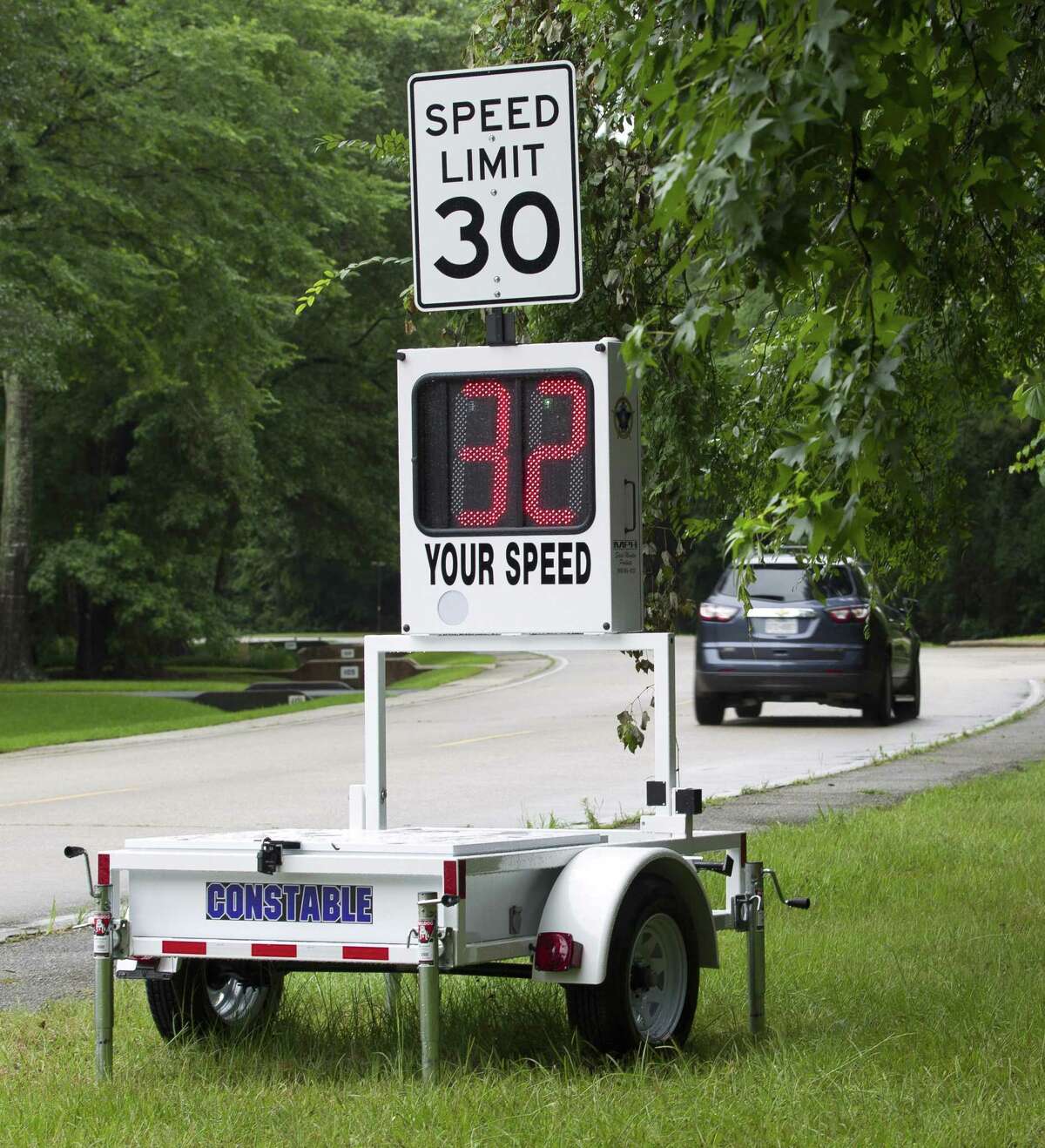 Motorists on Grogan's Point Road pass by a new speed trailer deployed by Montgomery County Precinct 3 Constable's Office in the Grogan's Mill subdivision, Wednesday, June 5, 2019, in The Woodlands. The new trailer, awarded through a nearly $10,000 grant by Texas Governor Greg Abbott's office, shows drivers how fast they are going as a speed deterrent.