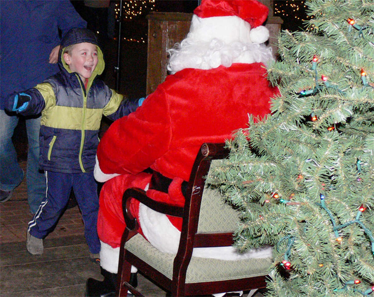A youngster runs toward Santa Claus at the Huntington Green tree-lighting ceremony.