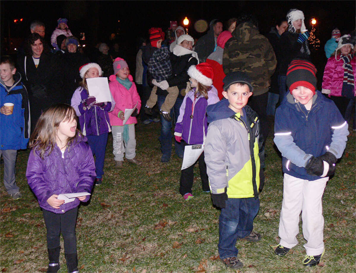 Youngsters wait to greet Santa Claus, who was just arriving on a Huntington fire truck.