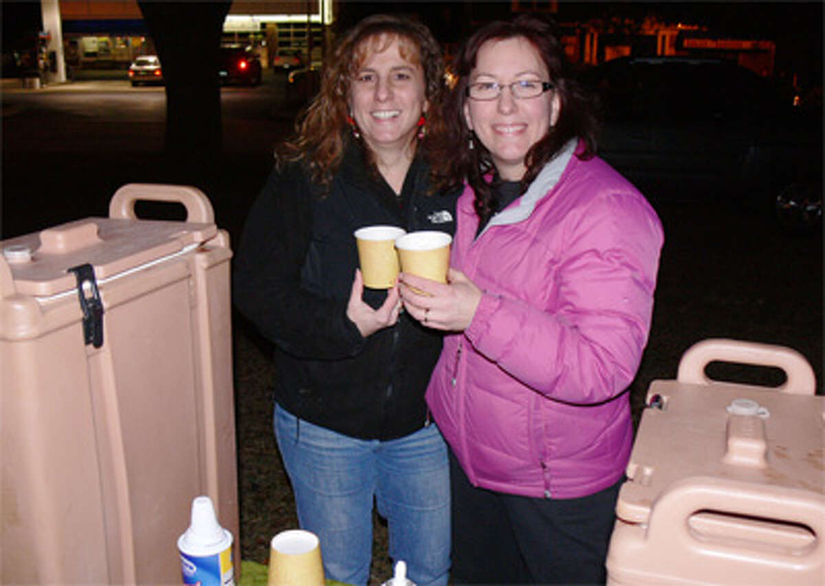 Maria Deaguila, right, owner of Auntie’s Cafe, and her sister Annette Halko provide free hot cocoa and muffins to people at the Huntington Green tree-lighting. Auntie’s Cafe in Huntington Center specializes in breakfast, lunch, coffee drinks and baked goods.