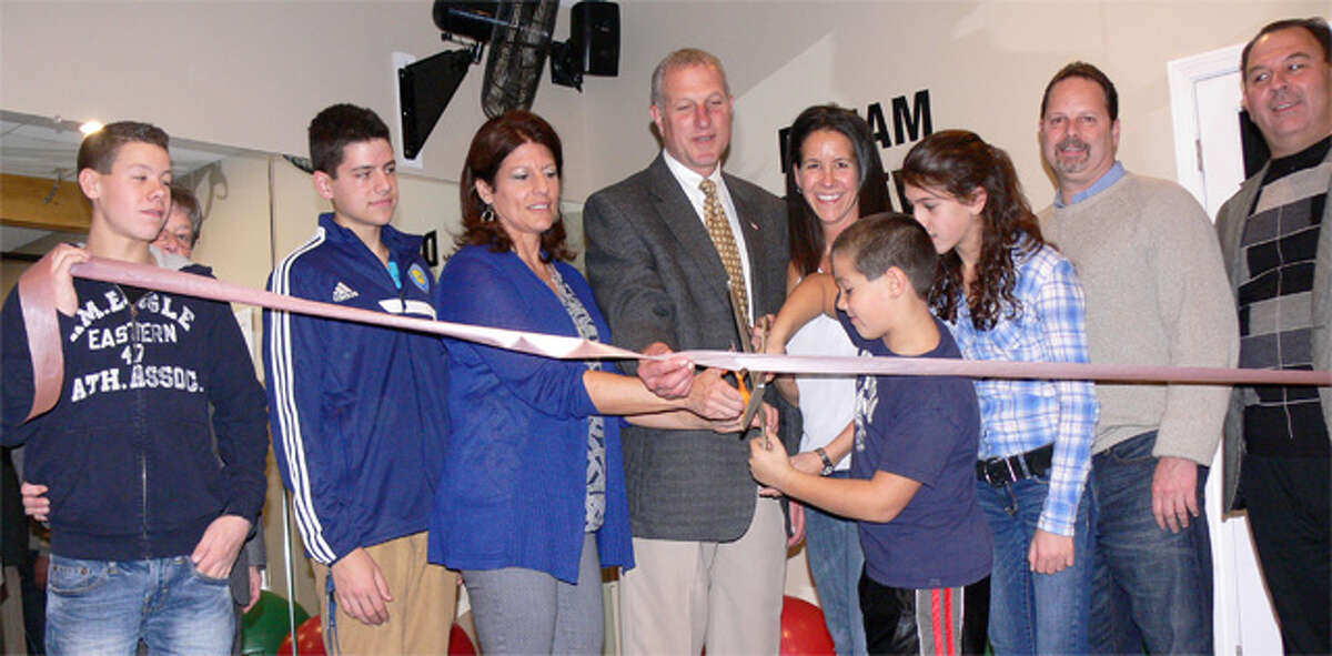Mayor Mark Lauretti joins Taylor-Made Fitness co-owners Renee Daconto and Patricia Taylor, as well as family members and other guests, at a ribbon-cutting ceremony to open the business.