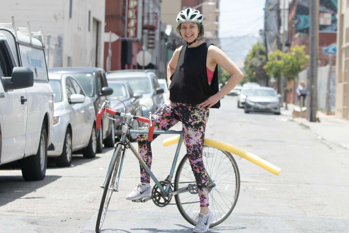 SFGATE Producer Michelle Robertson poses for a portrait with a pool noodle attached to her bicycle. She wanted to discover how difficult it would be to ride with one in San Francisco.