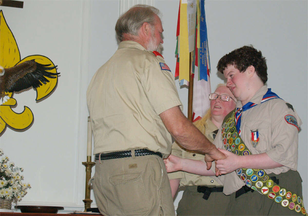 Joshua Sussan, right, of Shelton receives congratulations from Scoutmaster Mark Krom of Troop 1 during his Eagle Scout ceremony.