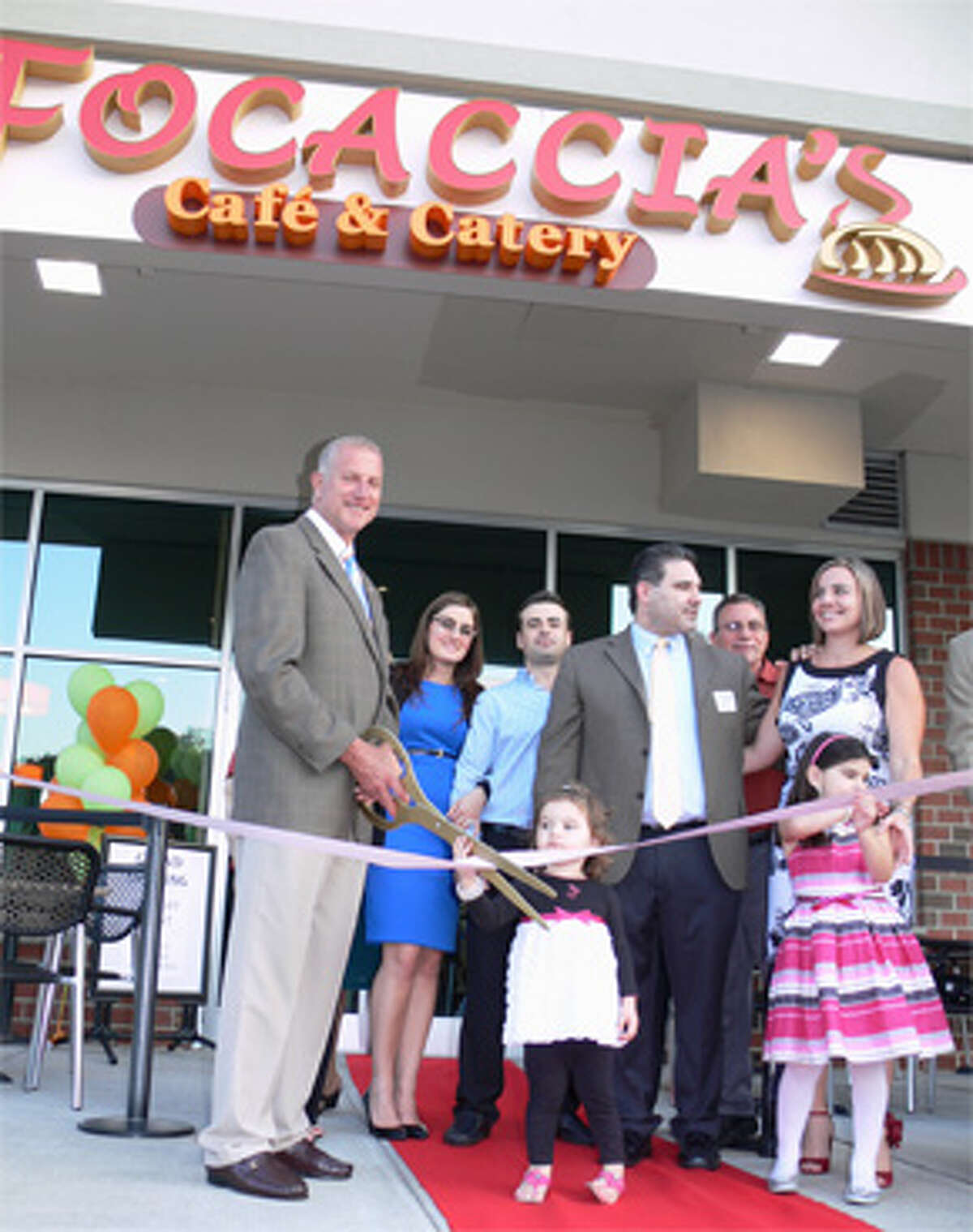 Mayor Mark Lauretti joins the owners and their families to cut the ribbon at the grand opening.