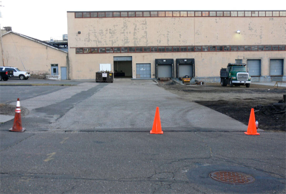 A view of the unused section of Hull Street, looking toward the Inline Plastics factory. The roadway covers the lighter colored asphalt area in the parking lot, going toward the building. In recent days, Inline Plastics has been rebuilding its parking lot near the “paper road” that is Hull Street.