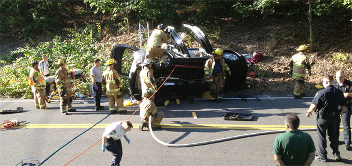 Shelton firefighters work to extricate an occupant of a SUV that landed on its side on Mohegan Road. (Submitted photo)