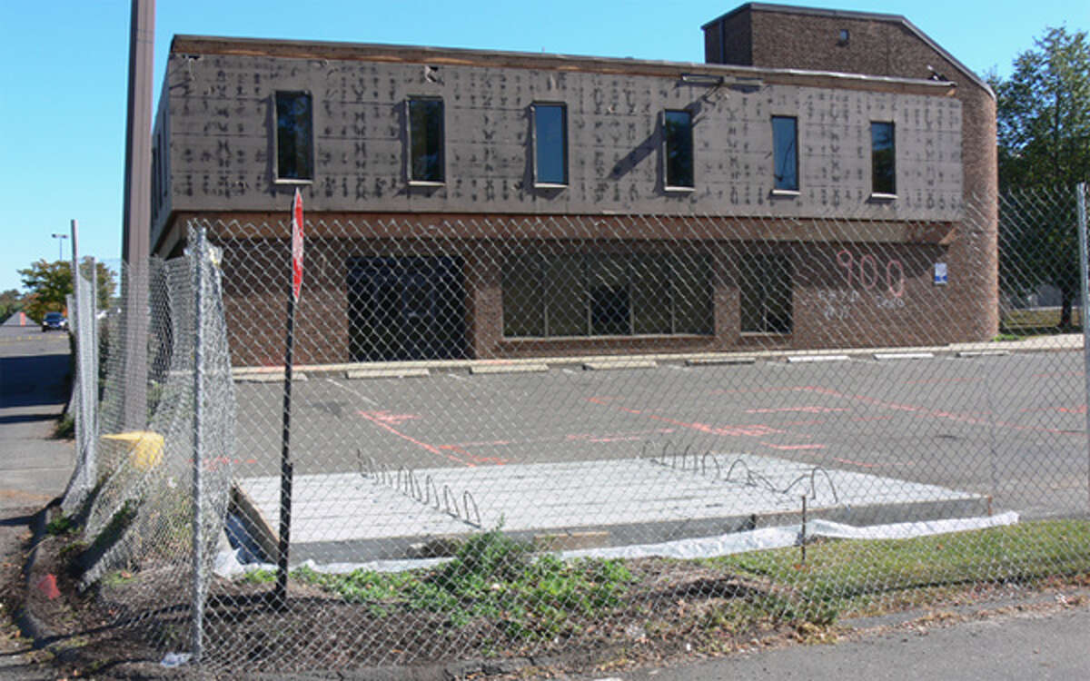 A chain-link fence has been put around the building that will be demolished to build a Stop & Shop gas station.
