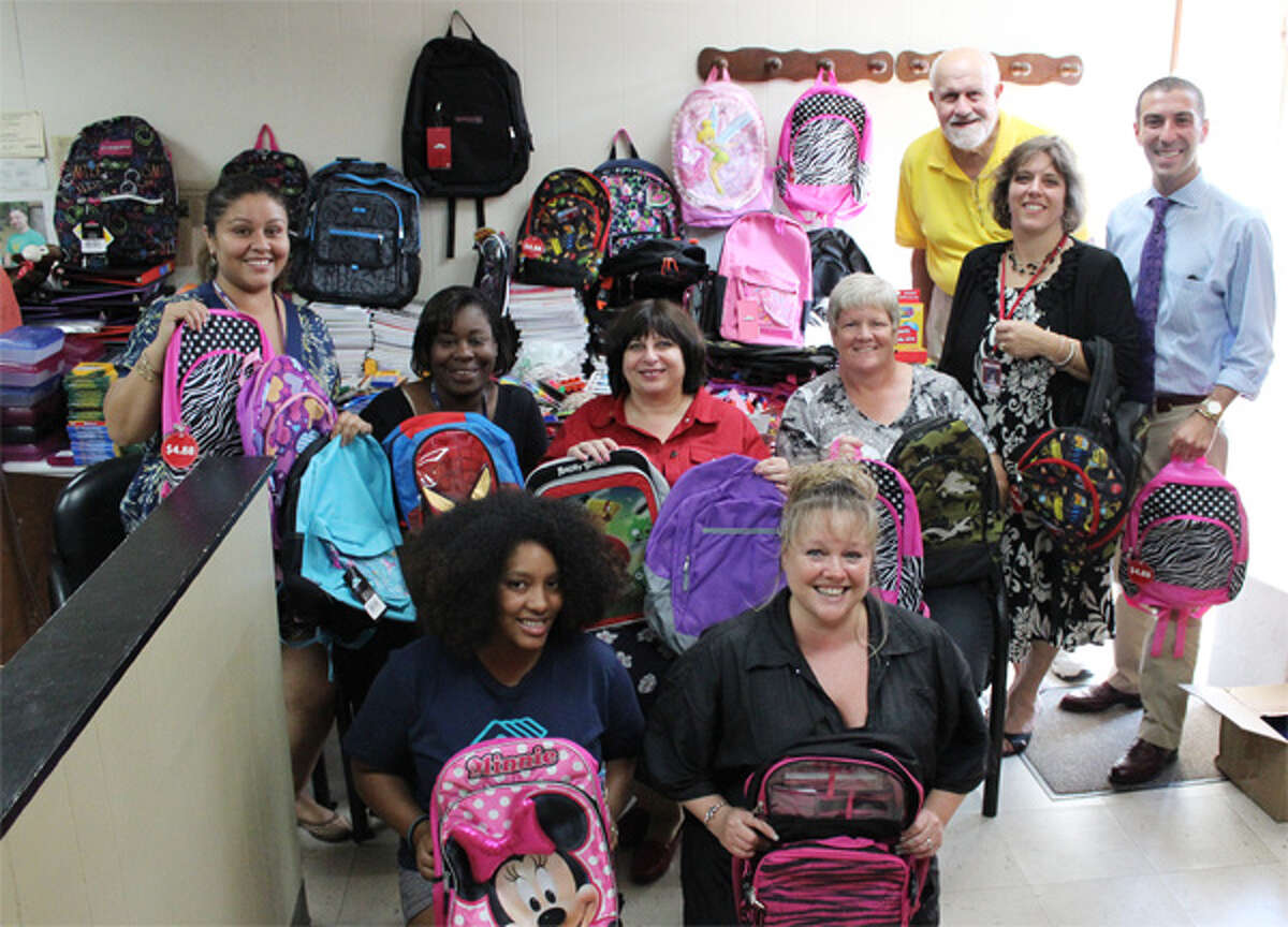 Showing the items collected are, in front: Michelle Sanders, Boys & Girls Club, and Jennifer Sneider, J Cuts. In back: Karen Martinez, Lower Naugatuck Valley Parent Child Resource Center (PCRC); Tylice MacDonald, PCRC; Suzanne Reilly, TEAM Inc.; Jane Bailey, Shelton School Readiness Council; Dave Haddad, Shelton Community Lions Club; Jennifer Olson, Irving School; and Tony Vellucci, Spooner House.