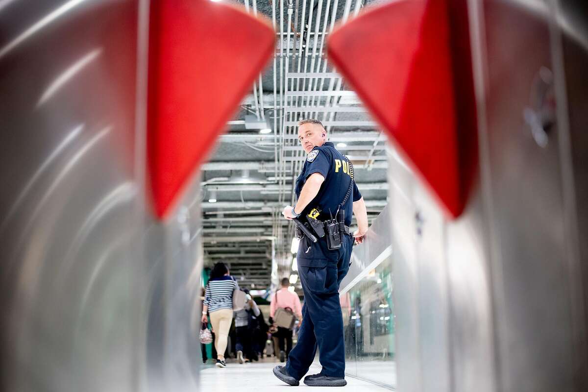 BART police Officer Zwetsloot watches for fare evaders at the Powell Street station on Wednesday, June 5, 2019, in San Francisco. Beginning in April, BART police officers and fare inspectors increased efforts to catch fare evaders who cost the system millions.