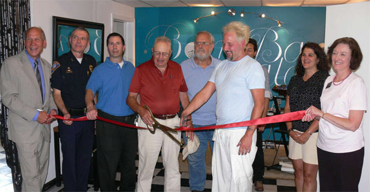 Dignitaries and the owners line up for the ribbon cutting ceremony inside the new Bomba Salon in Shelton.