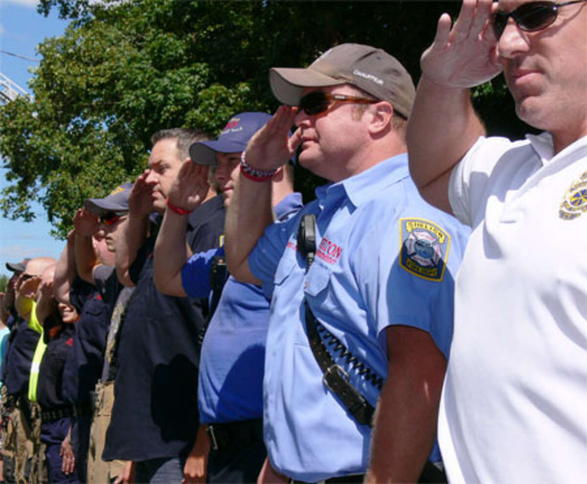 Shelton firefighters, including close friend Paul Wilson, far right (in white shirt), salute Pete Nichio upon his arrival.