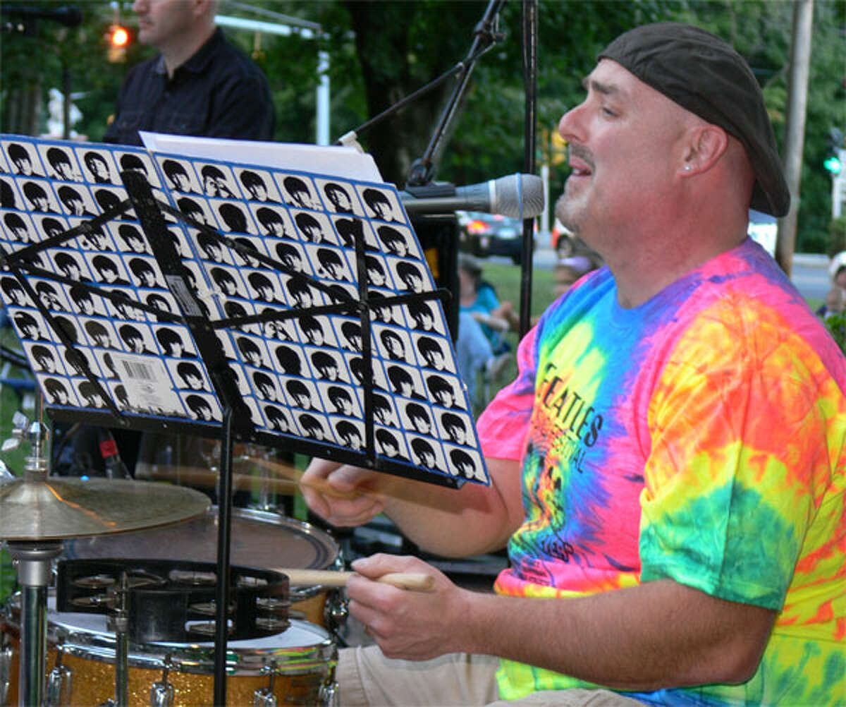 Ken Seidenburg, drummer for the Fools on the Hill band, sings a Beatles song during the Huntington Green concert.