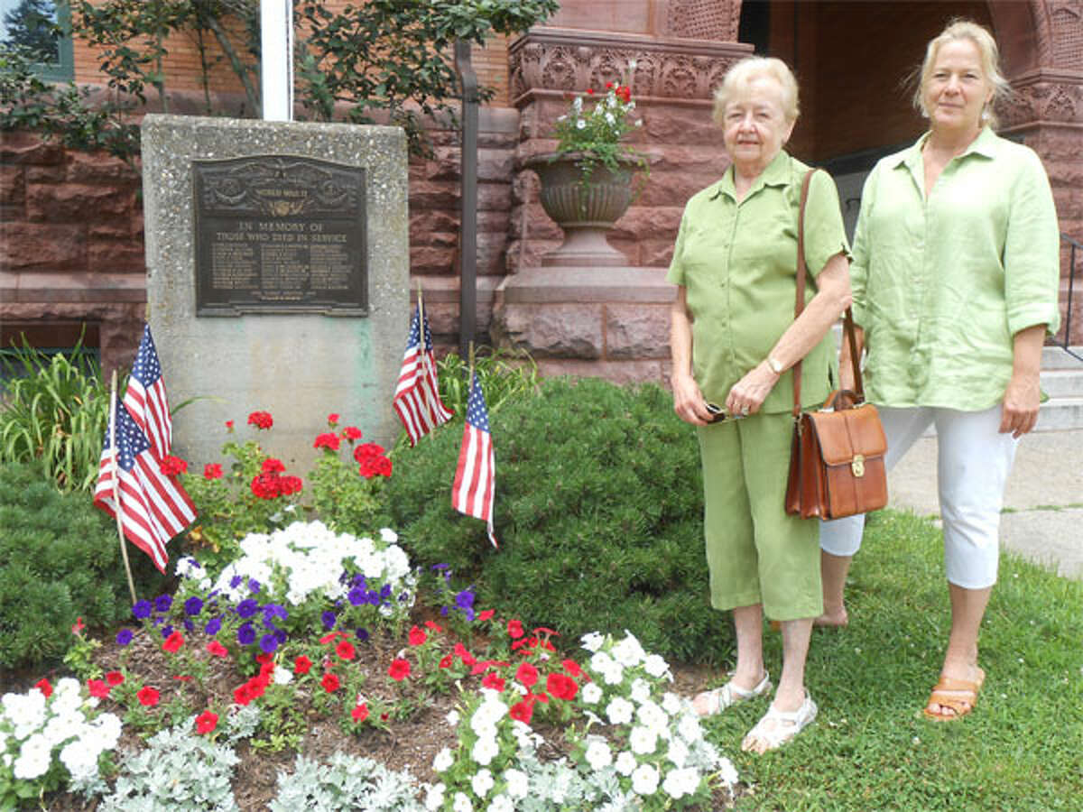 Joyce Donnelly, left, Olde Ripton Garden Club president, and Renee Marsh, vice president, stand near the holiday garden planted in front of Plumb Memorial Library. (Photo by Karen Kovacs Dydzuhn)