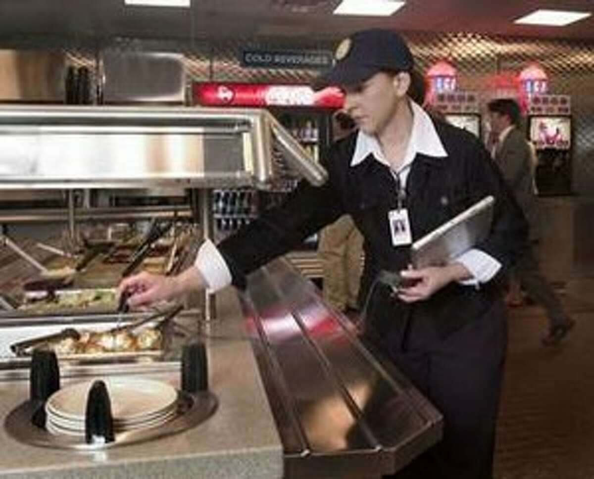 A health inspector checks the temperature of food at a buffet.