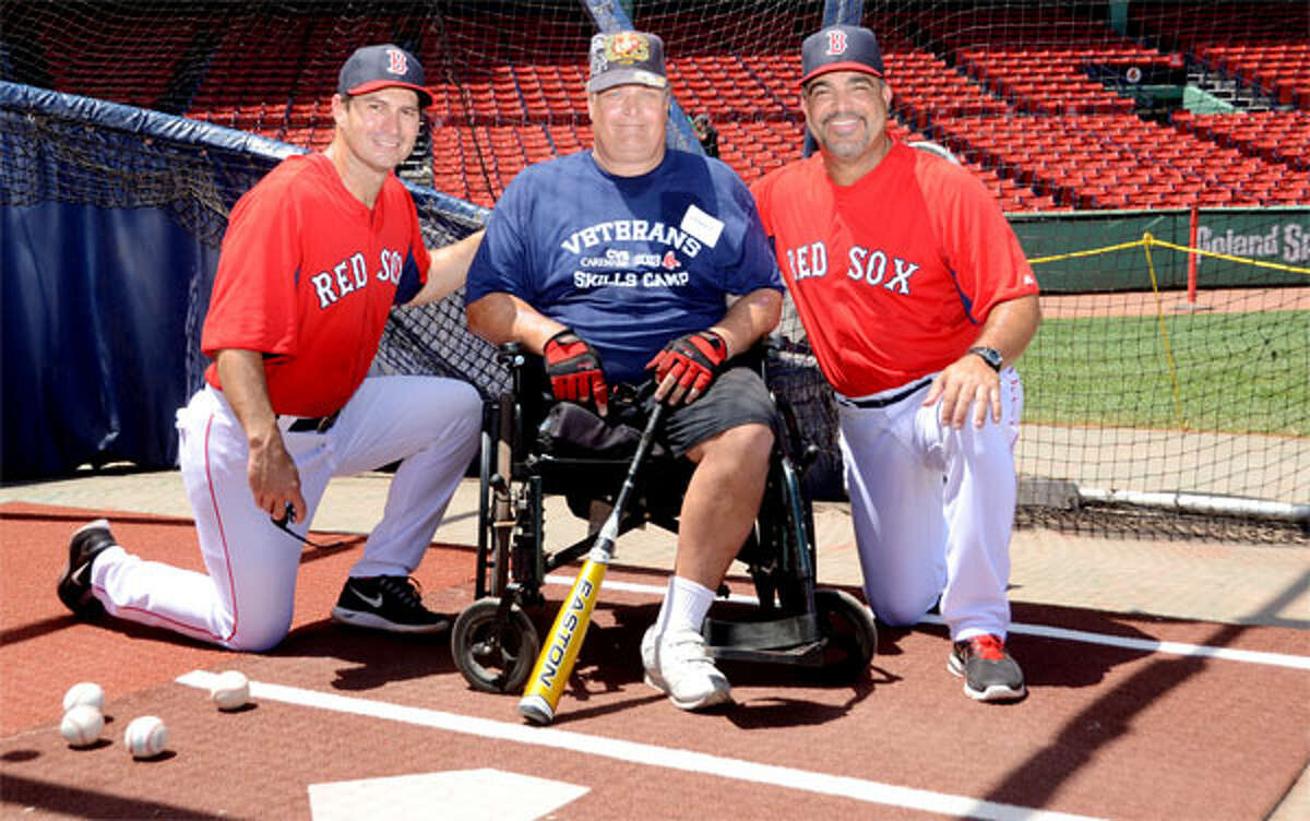 Boston Red Sox hitting coach Greg Colbrunn, left, and assistant hitting coach Victor Rodriguez with military veteran George Eldridge of Shelton on the field at Fenway Park. (Photos by Constance Brown)