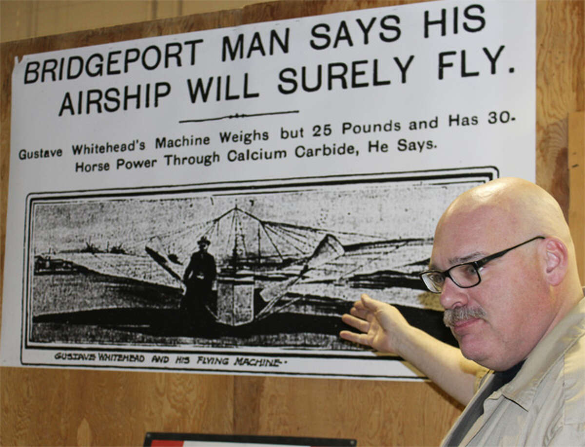 Andrew King, chief executive officer of the Connecticut Air and Space Center in Stratford, discusses early coverage of Gustave Whitehead’s attempts to fly in front of an enlargement of a front page at the time. The dimensions in the headline are erroneous, King said. (Photo by John Kovach)