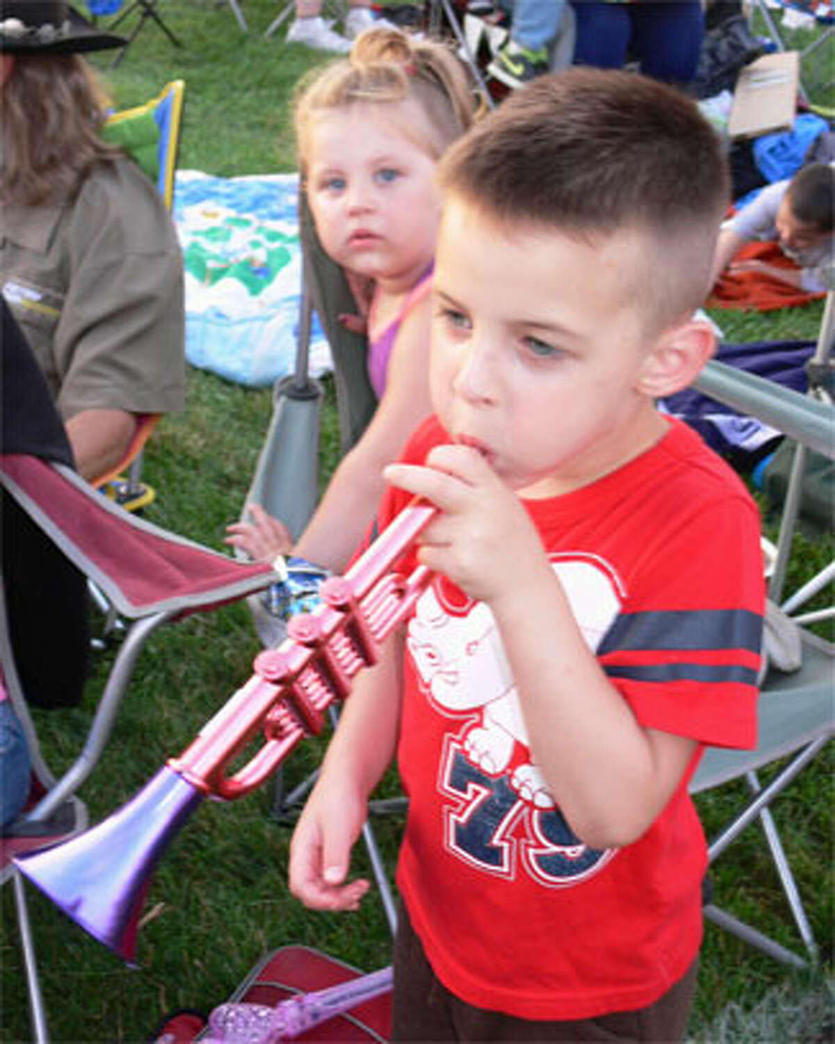Julian Barone, 5, plays a plastic trumpet while his sister Madeline, 2, observes. They were with father Kevin and other family members. (Photo by Brad Durrell)