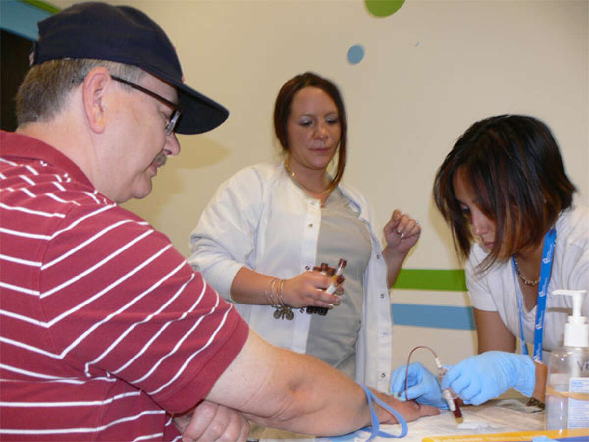Clint Richards gets his blood drawn for a PSA test by medical assistant Diana Campos, right, with assistance from phlebotomist Lisa Gavrish, during the 2013 Griffin Hospital Men’s Health Day at the Sports Center of Connecticut in Shelton.