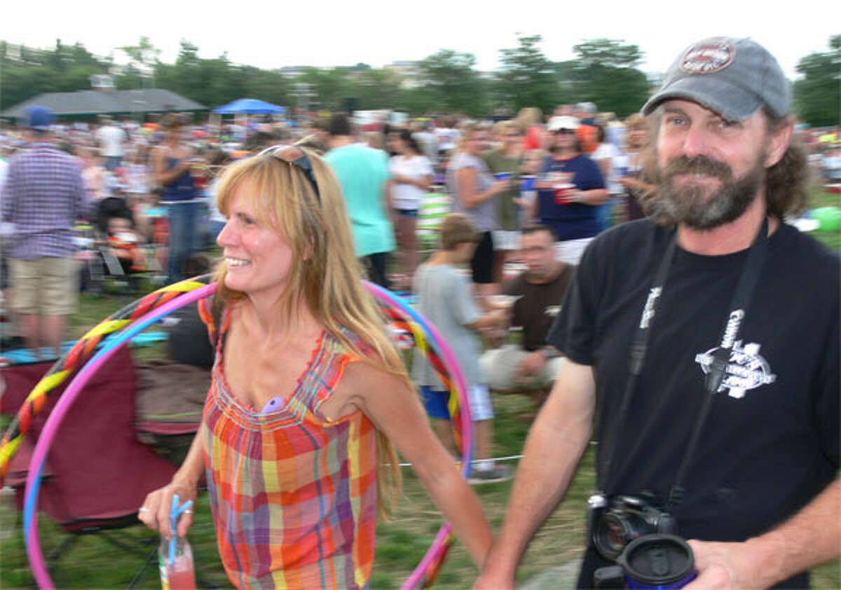 Brenda Krysinel, left, and her boyfriend David Pettis, both of Shelton, move through the crowd at the fireworks show with their hula-hoops. (Photo by Brad Durrell)