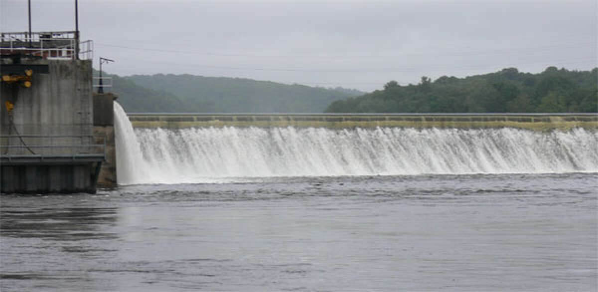 Water flows quickly over the Ousatonic Dam between Shelton and Derby on the Housatonic River, as viewed from the Shelton side near Canal Street.