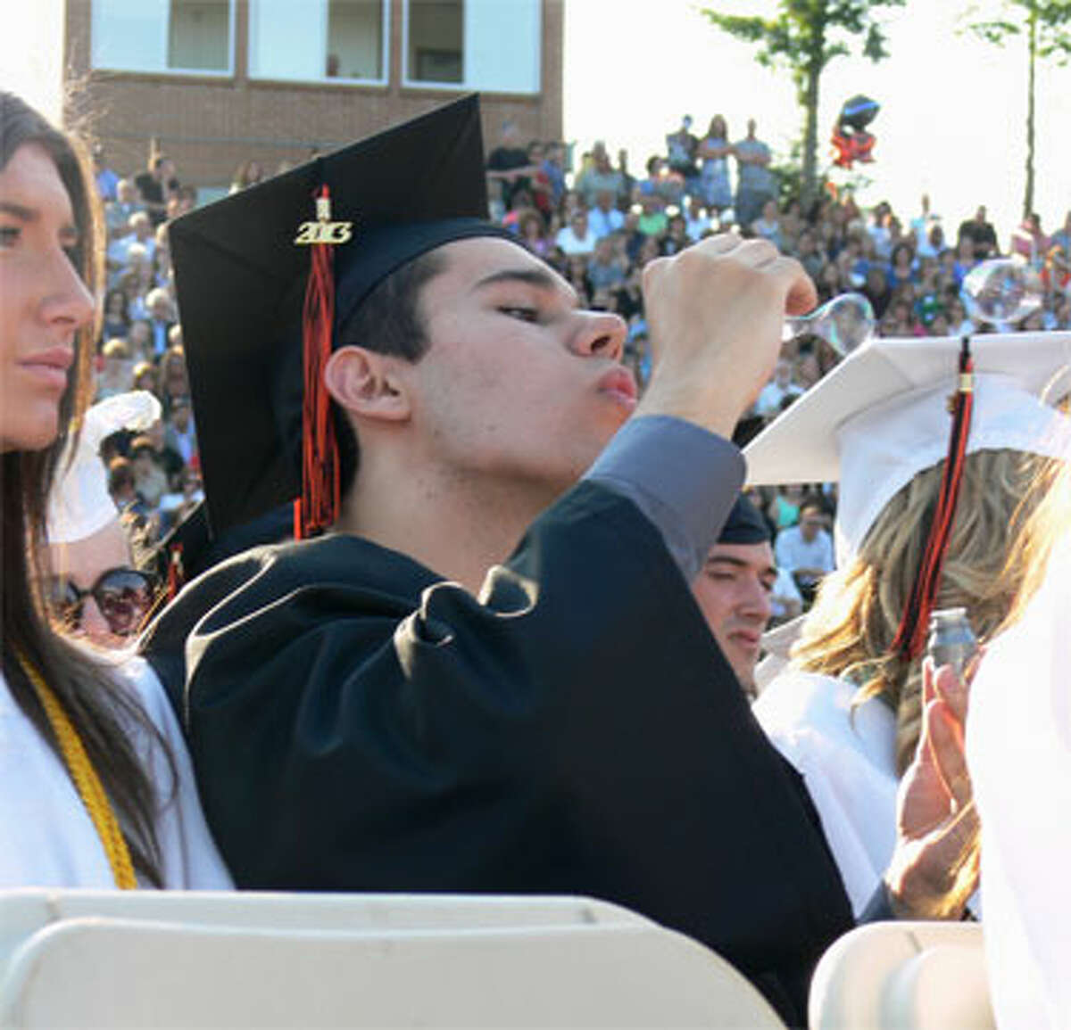 Shelton High graduate Adam Joseph Floczak blows bubbles during the ceremony.