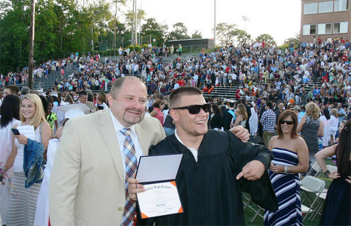 Graduate Dylan Cocca poses with Shelton High teacher Sam LaPaglia after receiving his diploma.