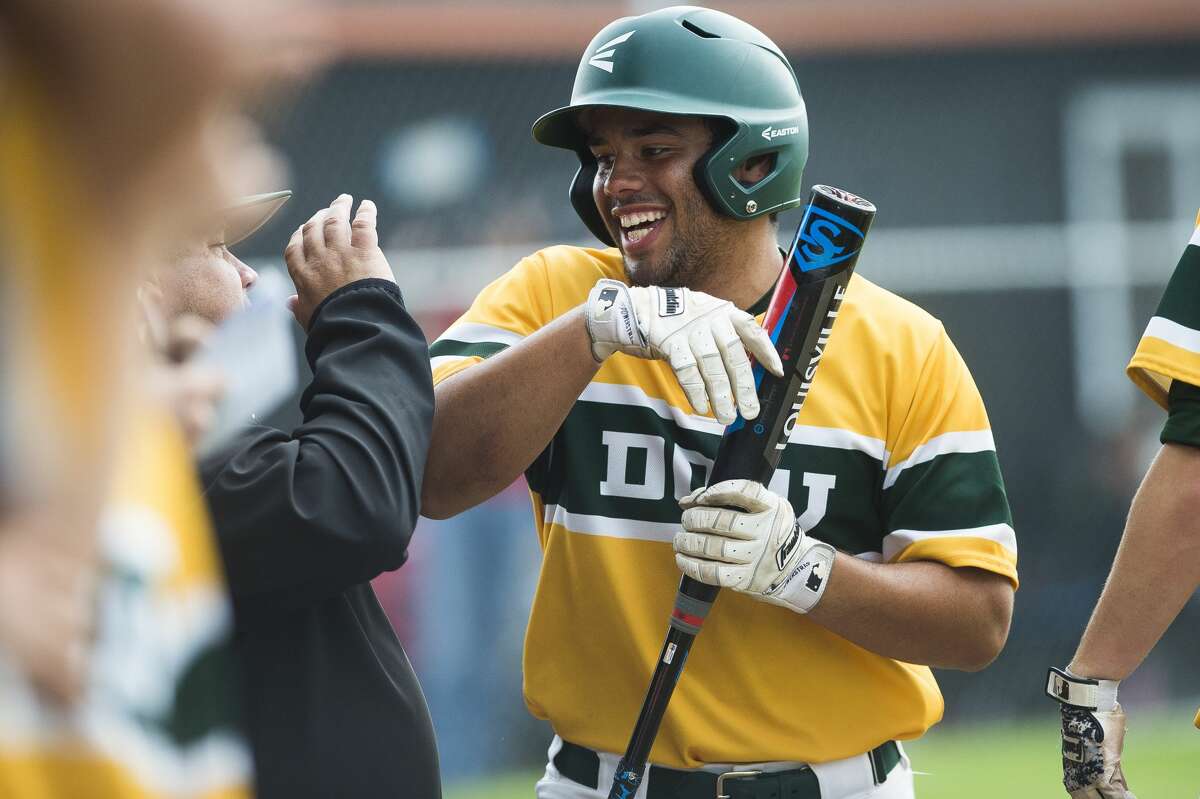 Dow's Avain Rivera high-fives a coach after scoring a run during a Division 1 regional semifinal game against Flushing on Wednesday, June 5, 2019 at Flushing High School. (Katy Kildee/kkildee@mdn.net)