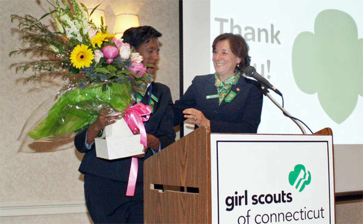 Outgoing Girl Scouts of Connecticut board President Teresa C. Younger of Shelton, left, receives a floral bouquet to recognize her volunteer service from the organization’s CEO, Mary Barneby.