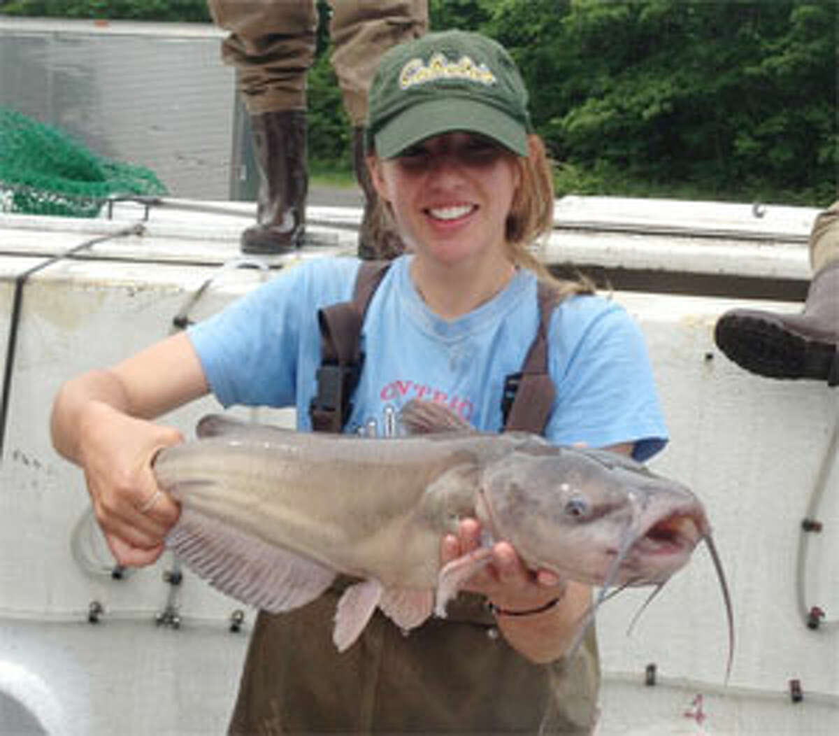 An angler holds up a catfish she caught in a Connecticut lake.