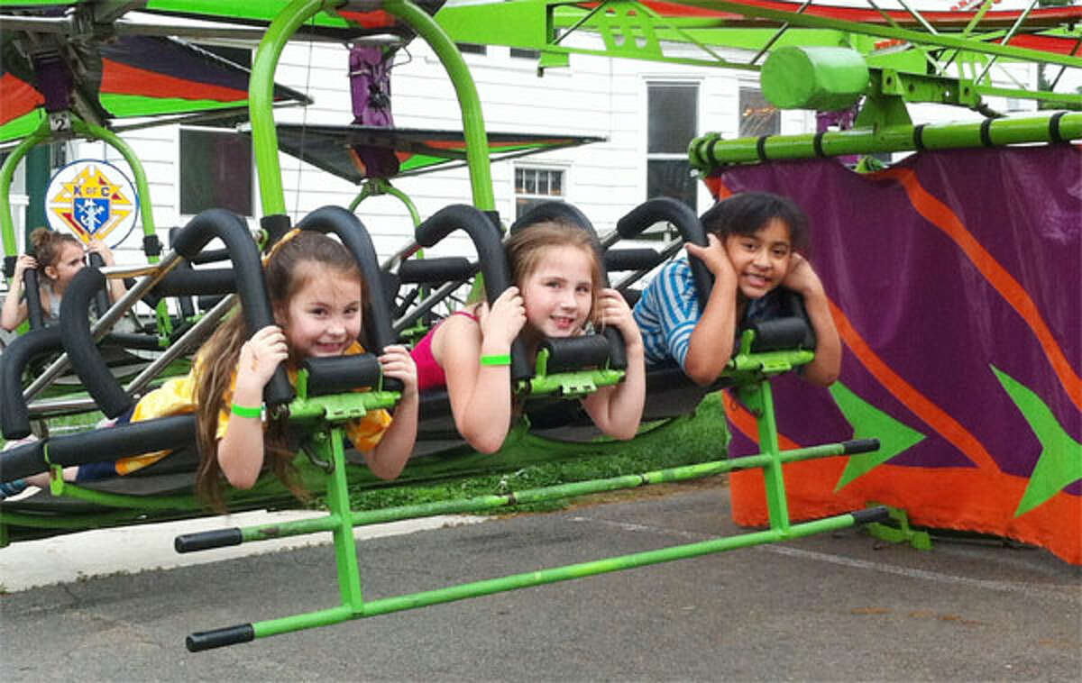 Going for a ride at the 2013 St. Joseph Carnival in Shelton are, from left, Emma Eschweiler, 7; Tatiana Bell, 7; and Natalia Ryzdik, 7, all of Shelton.