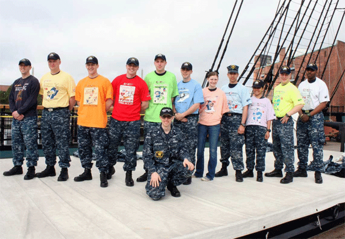 Crew members on the deck of the U.S.S. Constitution in Boston wear T-shirts from the Commodore Hull Thanksgiving Day 5K Road Race. They were given the 11 different T-shirts used in the Shelton/Derby race since it was founded in 2002.