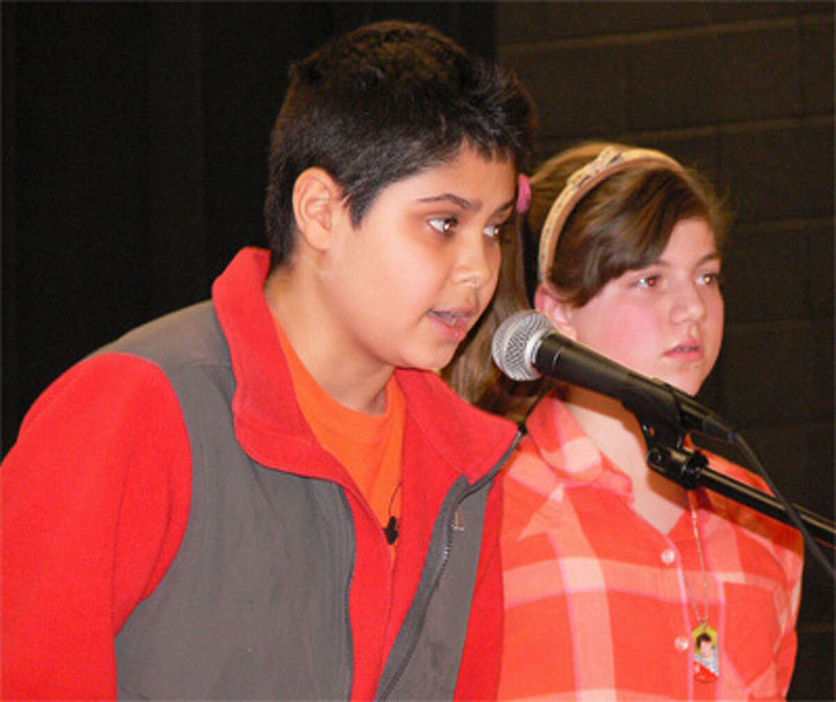 Winner Kamil Alkaul, left, spells a word with runner-up Megan Bisson in the background.