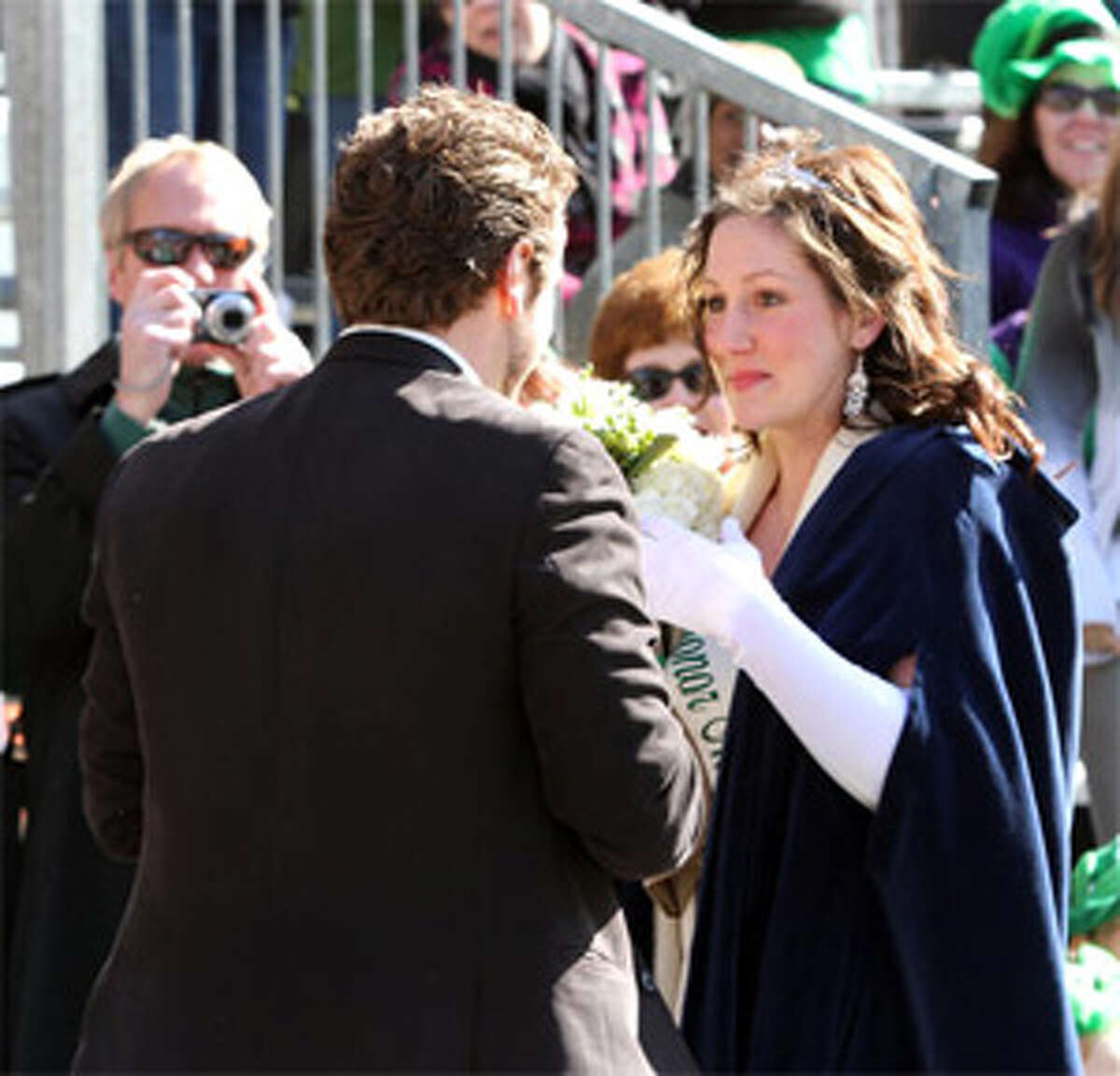 Kate Thompson with her fiancé, Dan Carr, as he proposes near the grandstand of the St. Patrick’s Day parade in New Haven.