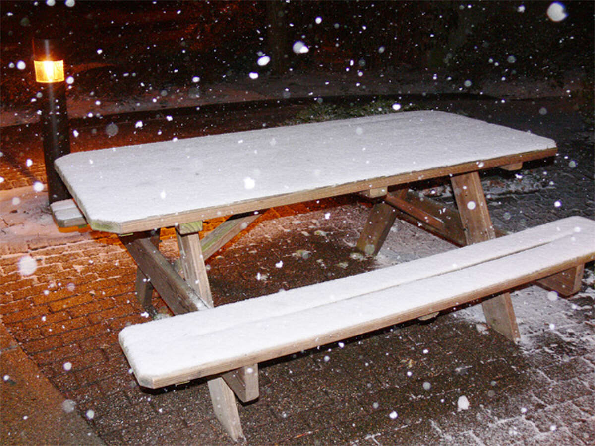 Snow covers a picnic table outside the Shelton Herald office on Bridgeport Avenue, as of about 8:45 p.m. Monday.