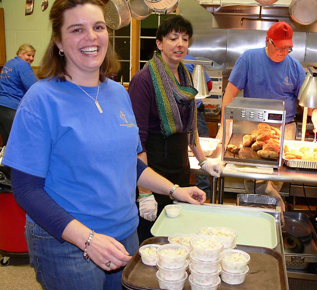 At a previous fish fry, the Rev. Heather Sinclair checks out the kitchen but spent much of her time interacting with guests in the dining room.