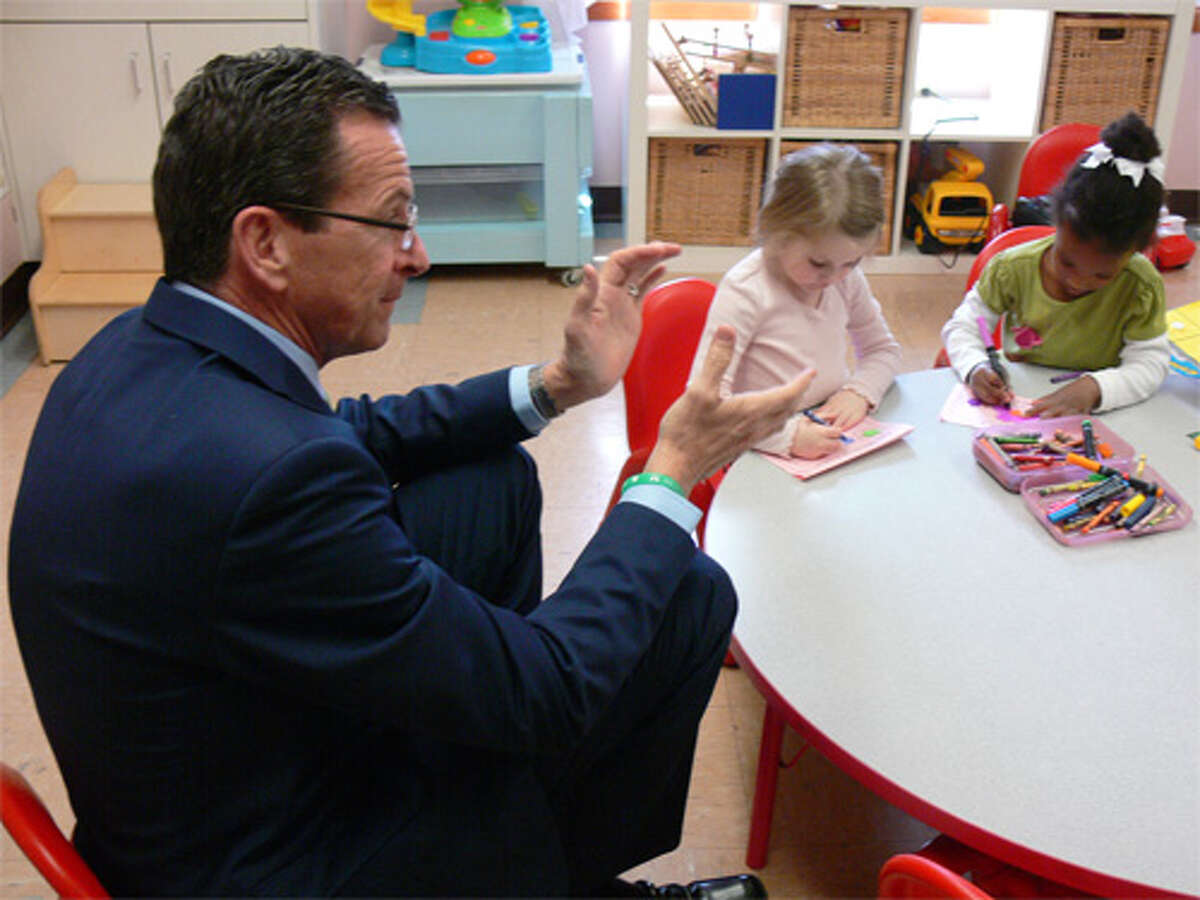 Gov. Dannel P. Malloy claps during a song in the classroom of Sylvie Lobsenz, who operates a language program at the Susanna Wesley School in Shelton.