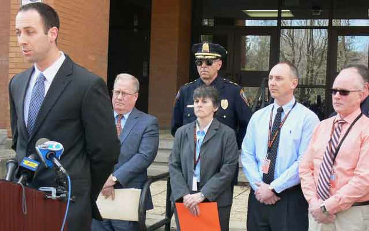 Shelton Police Lt. Robert Kozlowsky, left, answers questions from the media at Shelton High School while surrounded by school and police officials and a Ndoj family spokesman.
