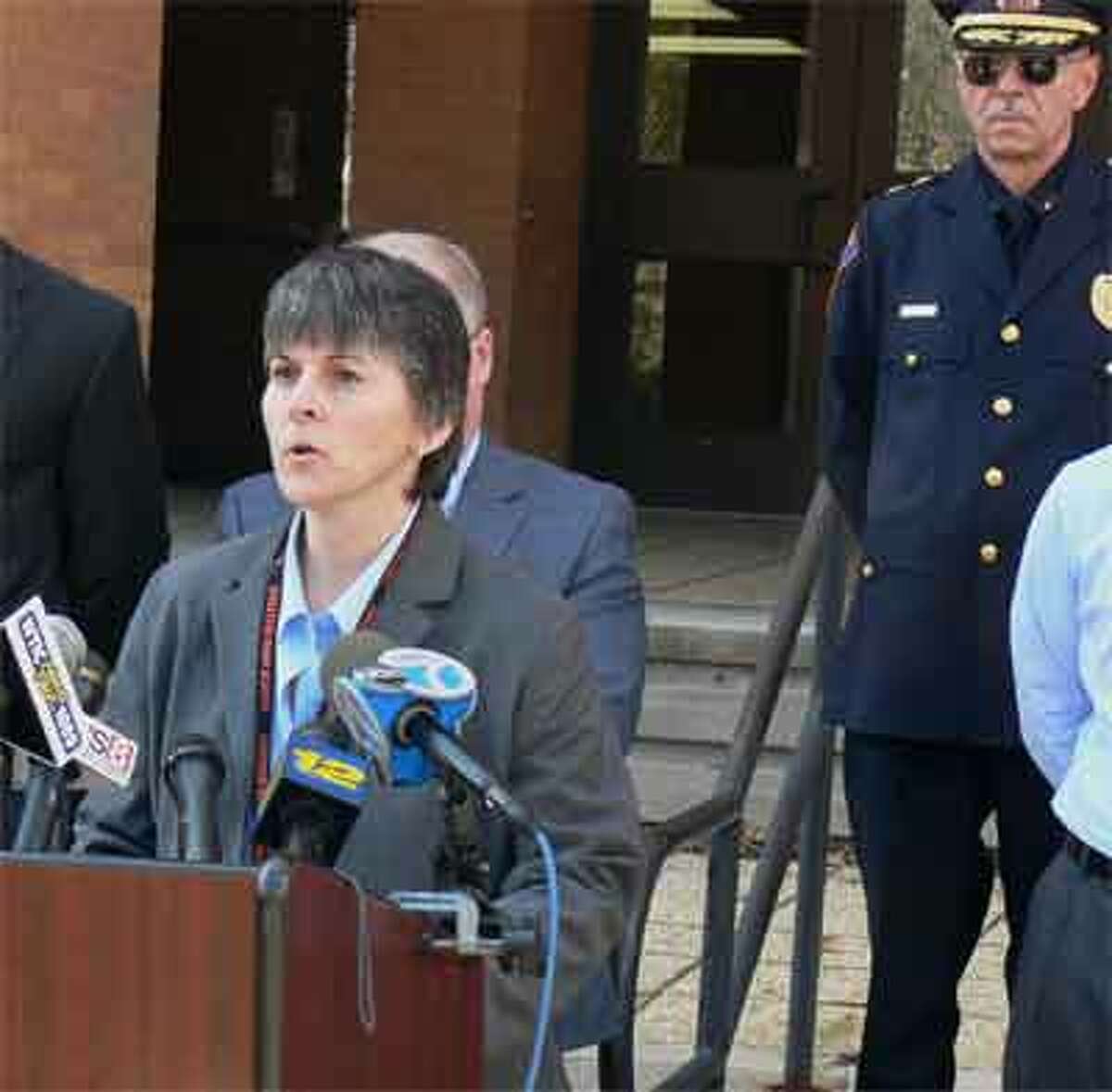 Shelton High School Headmaster Beth Smith addresses members of the media, with Shelton Police Chief Joel Hurliman standing in the background on the right.