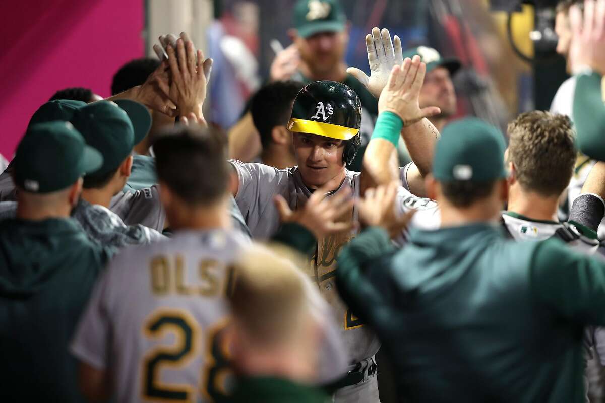 ANAHEIM, CALIFORNIA - JUNE 05: Marcus Semien #10 of the Oakland Athletics is congratulated in the dugout after scoring on a wild pitch during the eighth inning of a game against the Los Angeles Angels of Anaheimat Angel Stadium of Anaheim on June 05, 2019 in Anaheim, California. (Photo by Sean M. Haffey/Getty Images)